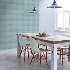 dining area with blue tiles wall and dining table with white chairs