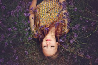 Woman lying in a field with her eyes closed