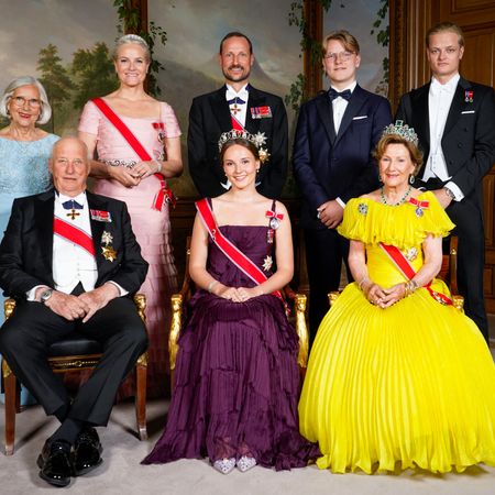 A formal portrait of the Norwegian royal family including the king, queen, crown prince and his family taken in 2022 posing in gowns, tiaras and tuxedos 