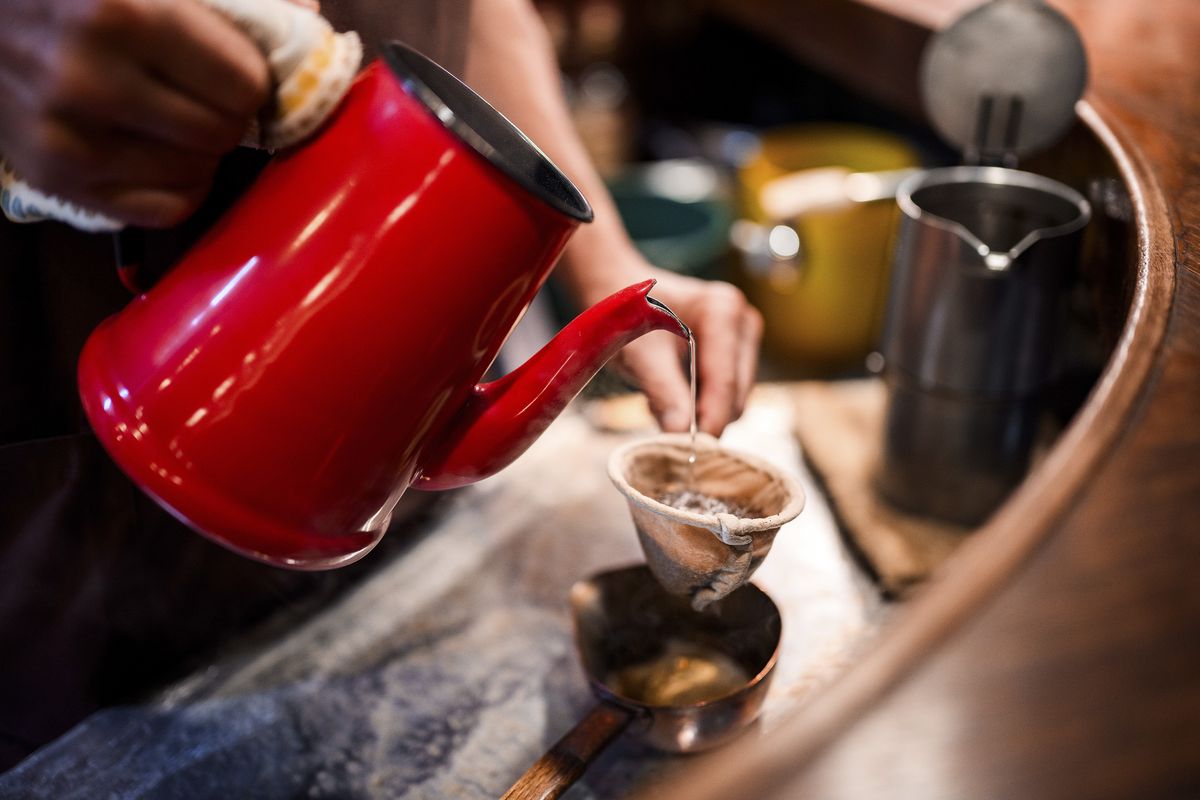 Hot drink being poured from bright red kettle, taken with Nikon Z 35mm f/1.2 S lens