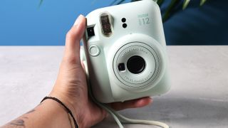 A mint green Fujifilm Instax mini 12 instant camera