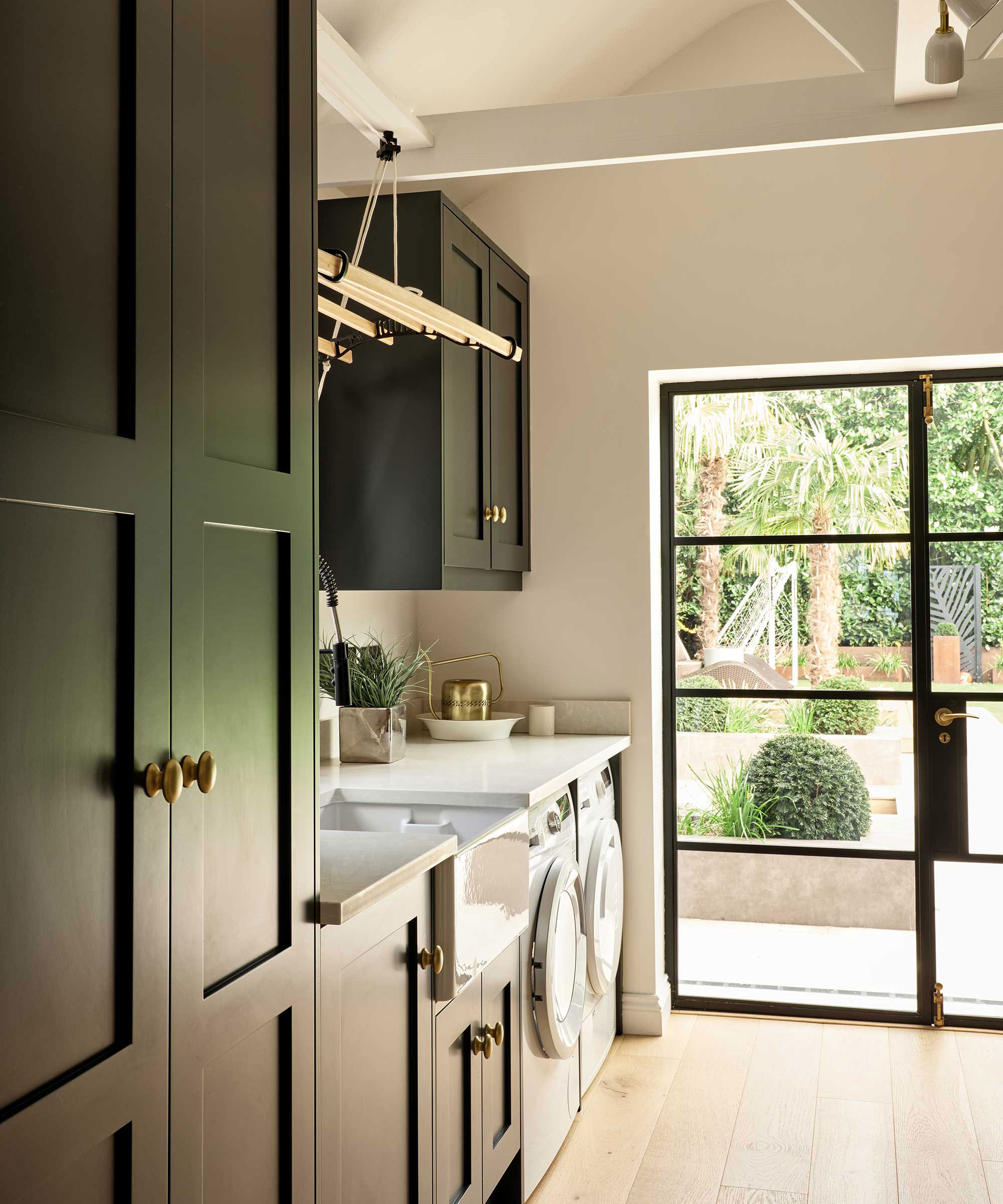 green utility room with clothes drying rack and black metal framed rear door