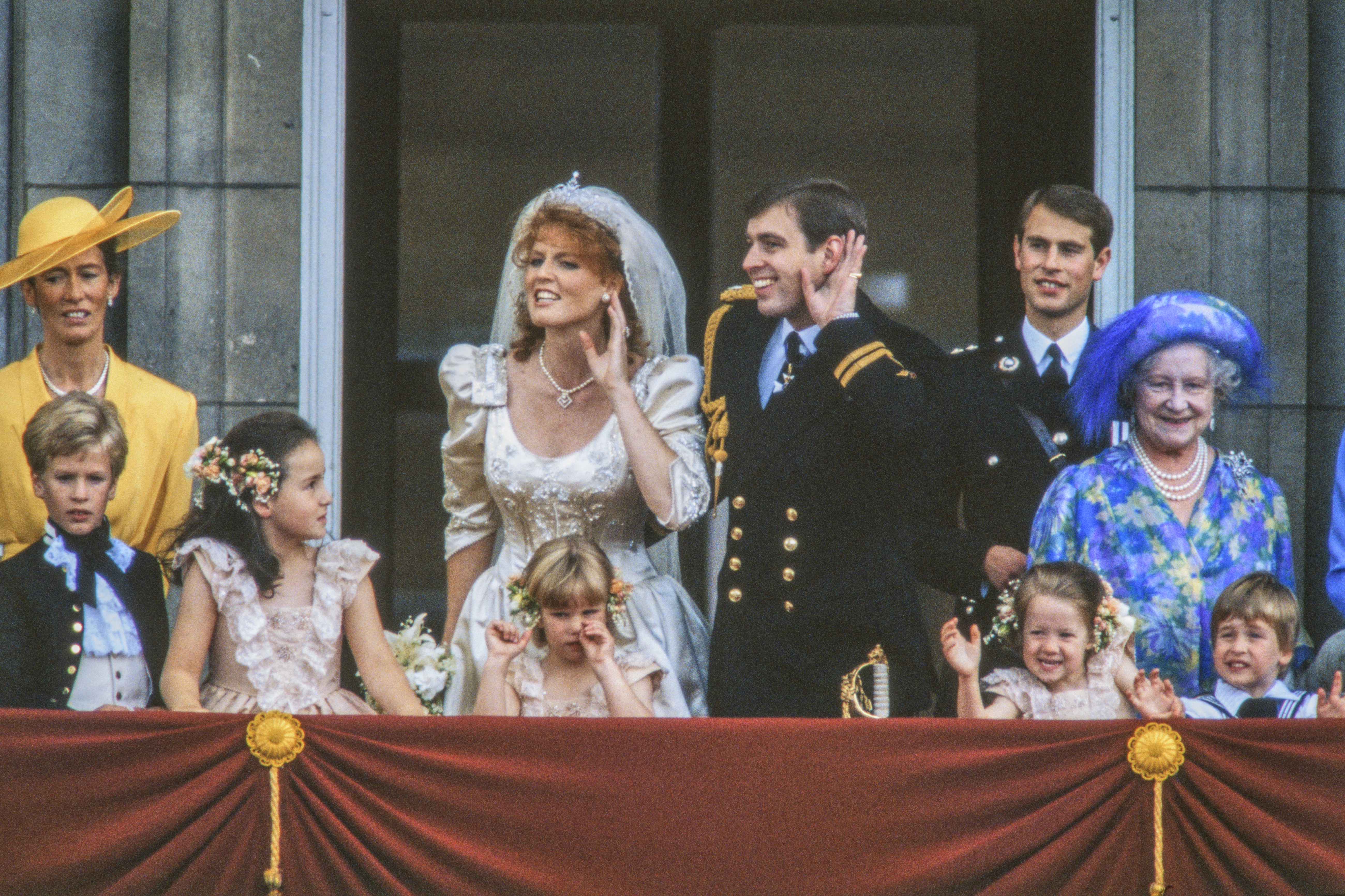 Sarah Ferguson and Prince Andrew cupping their hands around their ears on their wedding day on the palace balcony