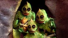 Still from 1970s TV show Land of the Lost featuring three dinosaur-style creatures