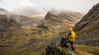 雨中站在小山上的徒步旅行者