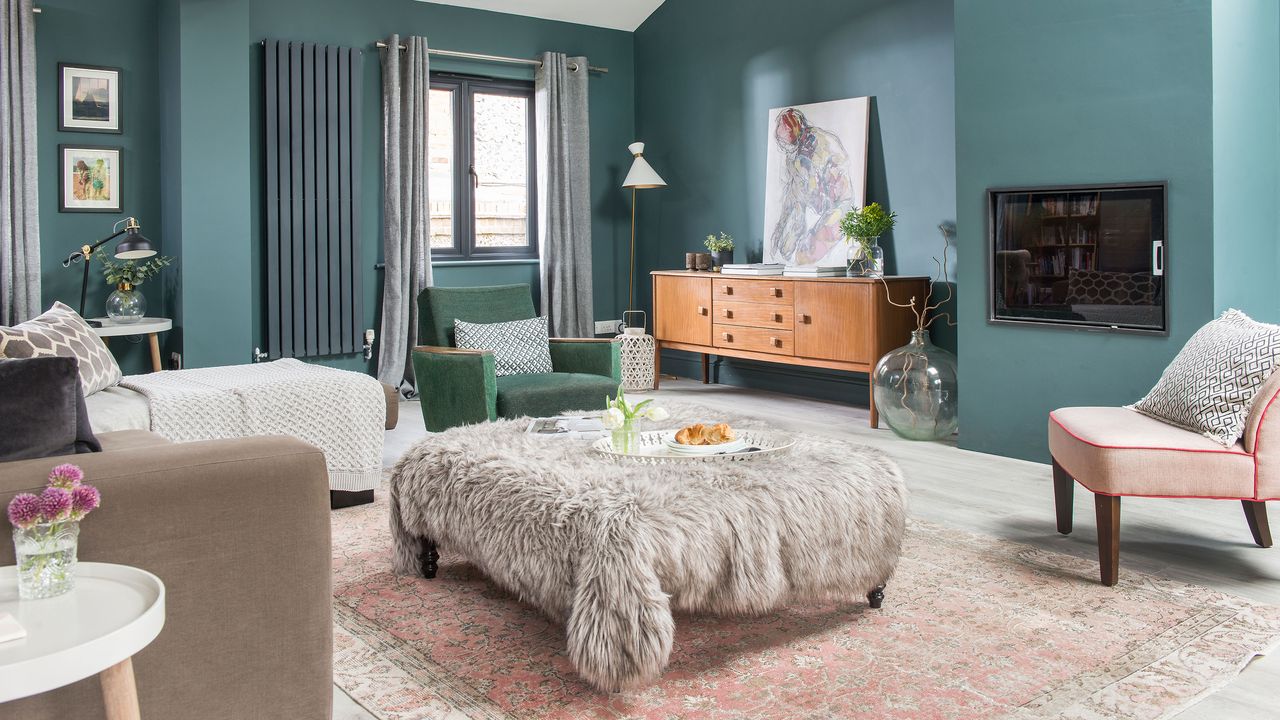 Blue living room with large footstool covered in faux fur throw and retro walnut sideboard