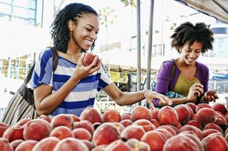 outdoor date ideas - Women shopping together at fruit stand