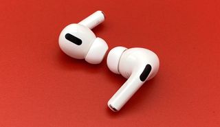 The AirPods Pro wireless earbuds laid up against red backdrop