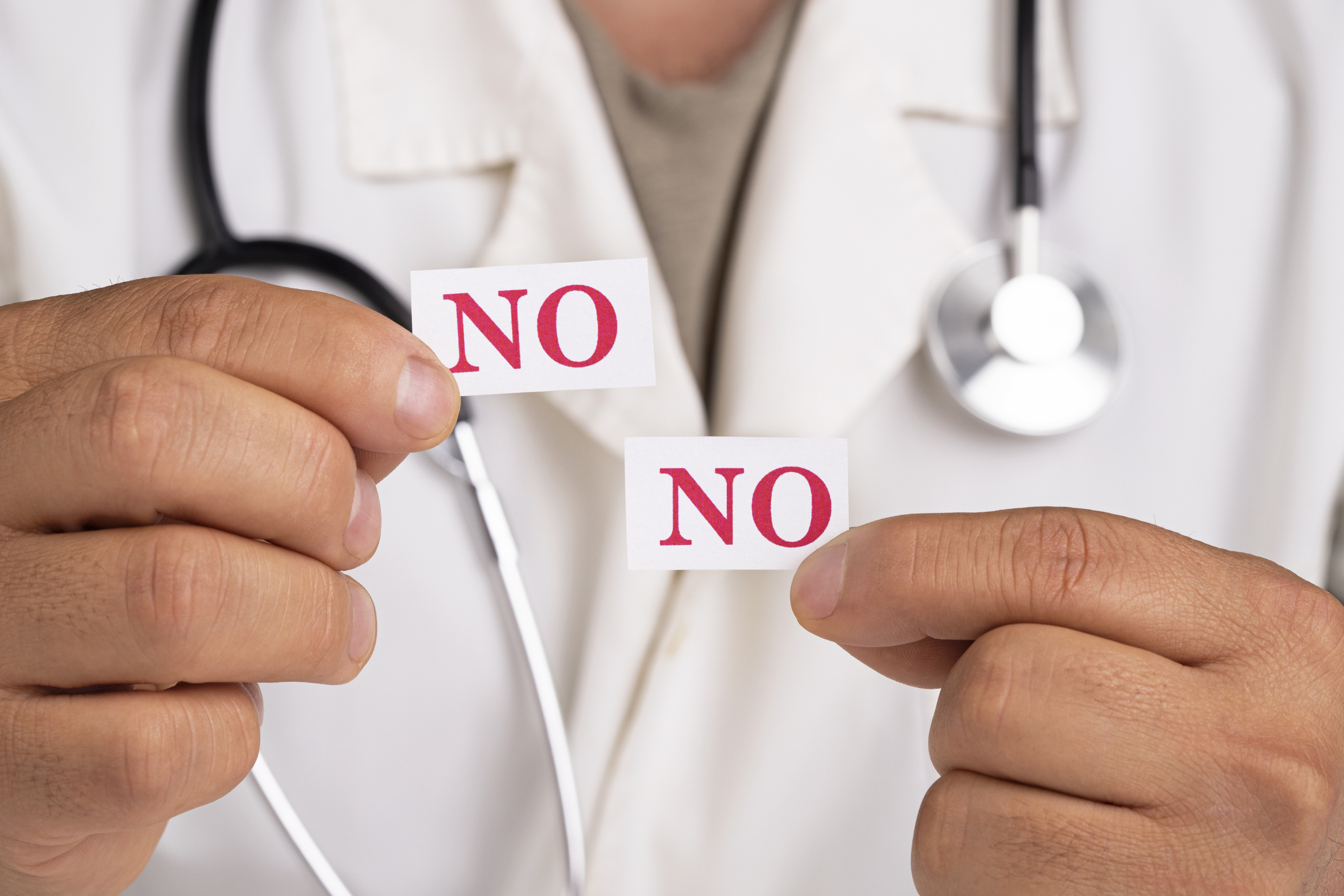 Doctor holding a cards with word No