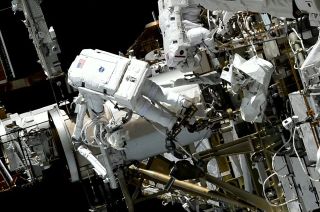 NASA astronaut Nicole Mann works to bolt together a mounting bracket for a new roll-out solar array while standing atop an articulated portable foot restraint (APFR) during a spacewalk outside of the International Space Station on Friday, Jan. 20, 2023. Koichi Wakata of the Japan Aerospace Exploration Agency (JAXA) can also be seen to the right.