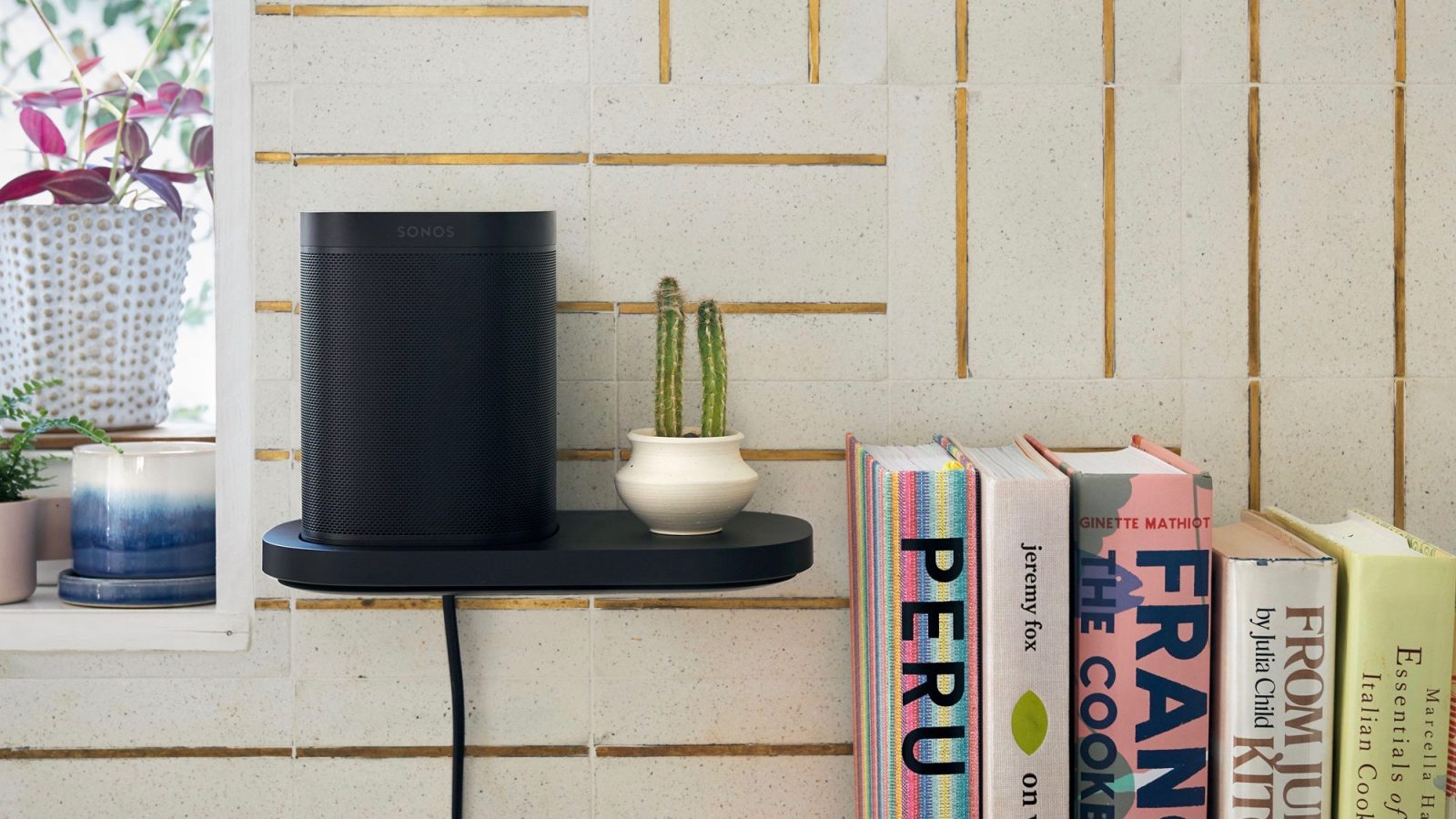 the sonos one mounted on a charging shelf