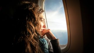 woman looking out of plane window