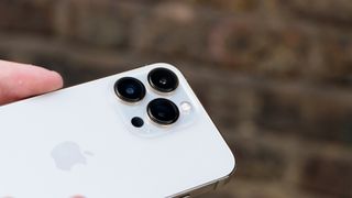 Weißes iPhone 13 Pro, bei dem die Rückseite und die Kameralinsen zu sehen sind