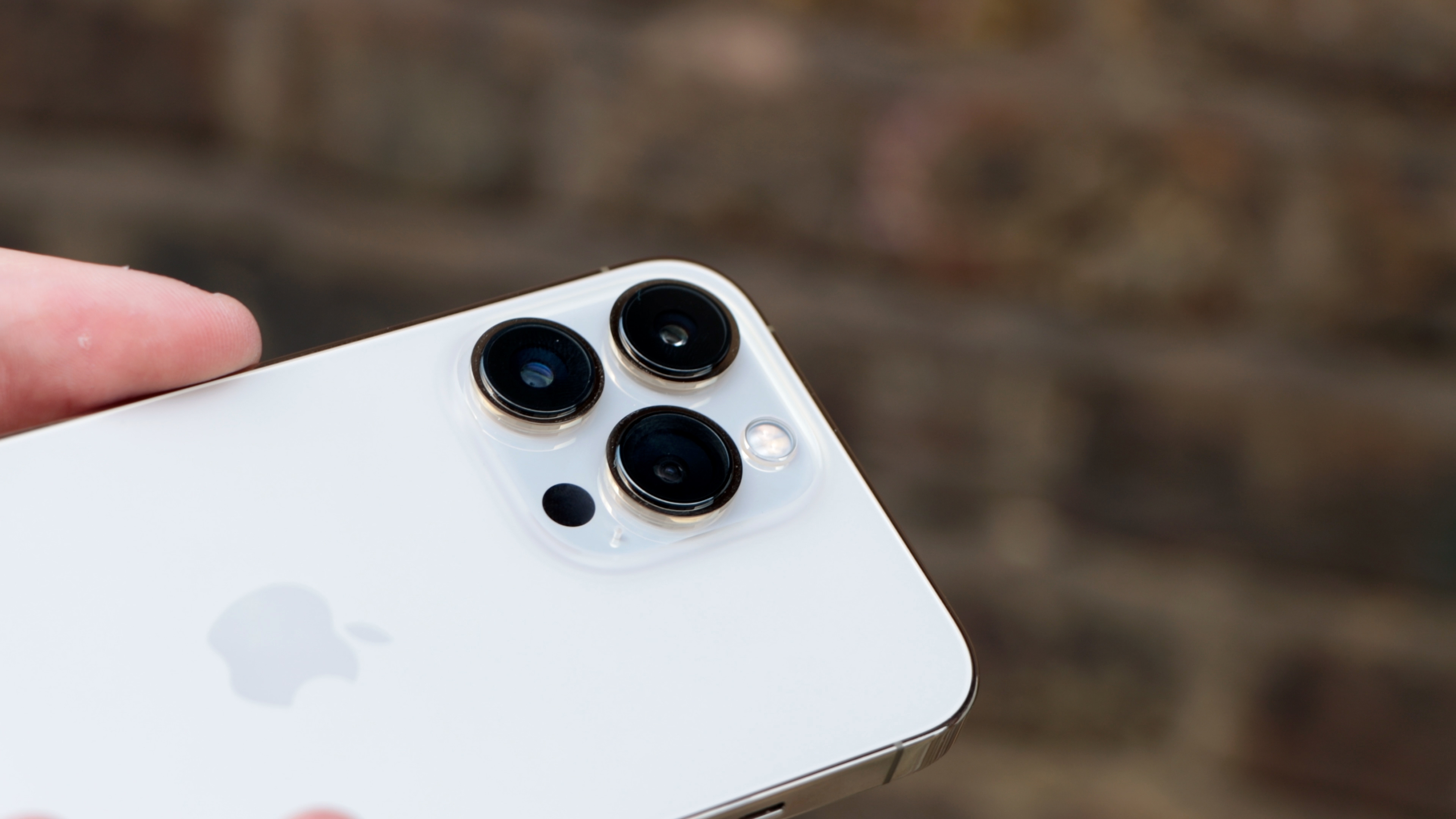 iPhone 13 Pro berwarna putih, dengan sisi belakang dan lensa kamera terlihat