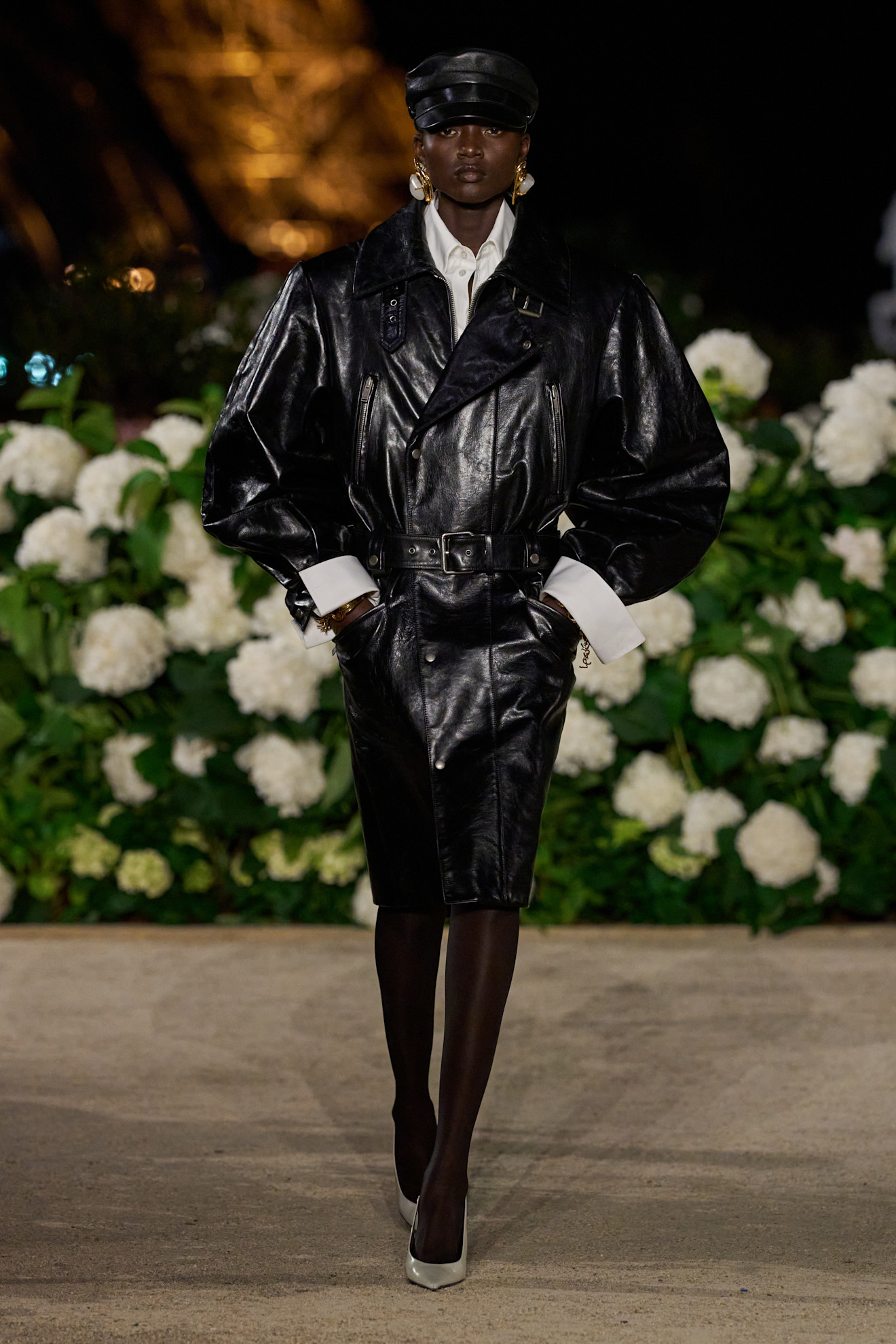 a model on the saint laurent runway wearing a leather trench