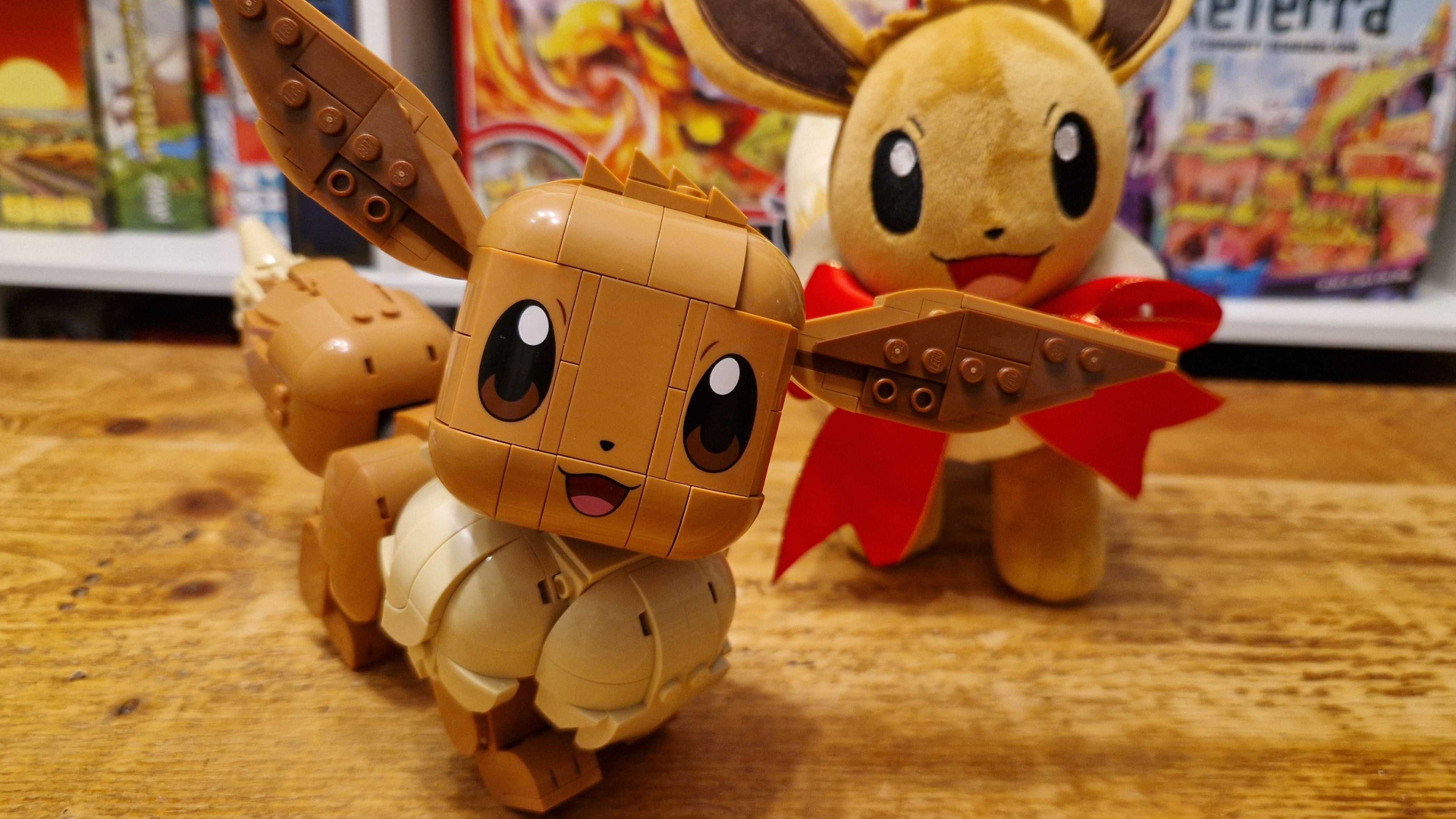 Lego Eevee on a wooden table in front of an Eevee plush toy
