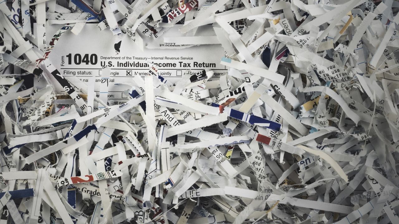 A 1040 US Individual Income Tax Return among heaps of shredded paper