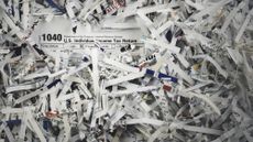 A 1040 US Individual Income Tax Return among heaps of shredded paper