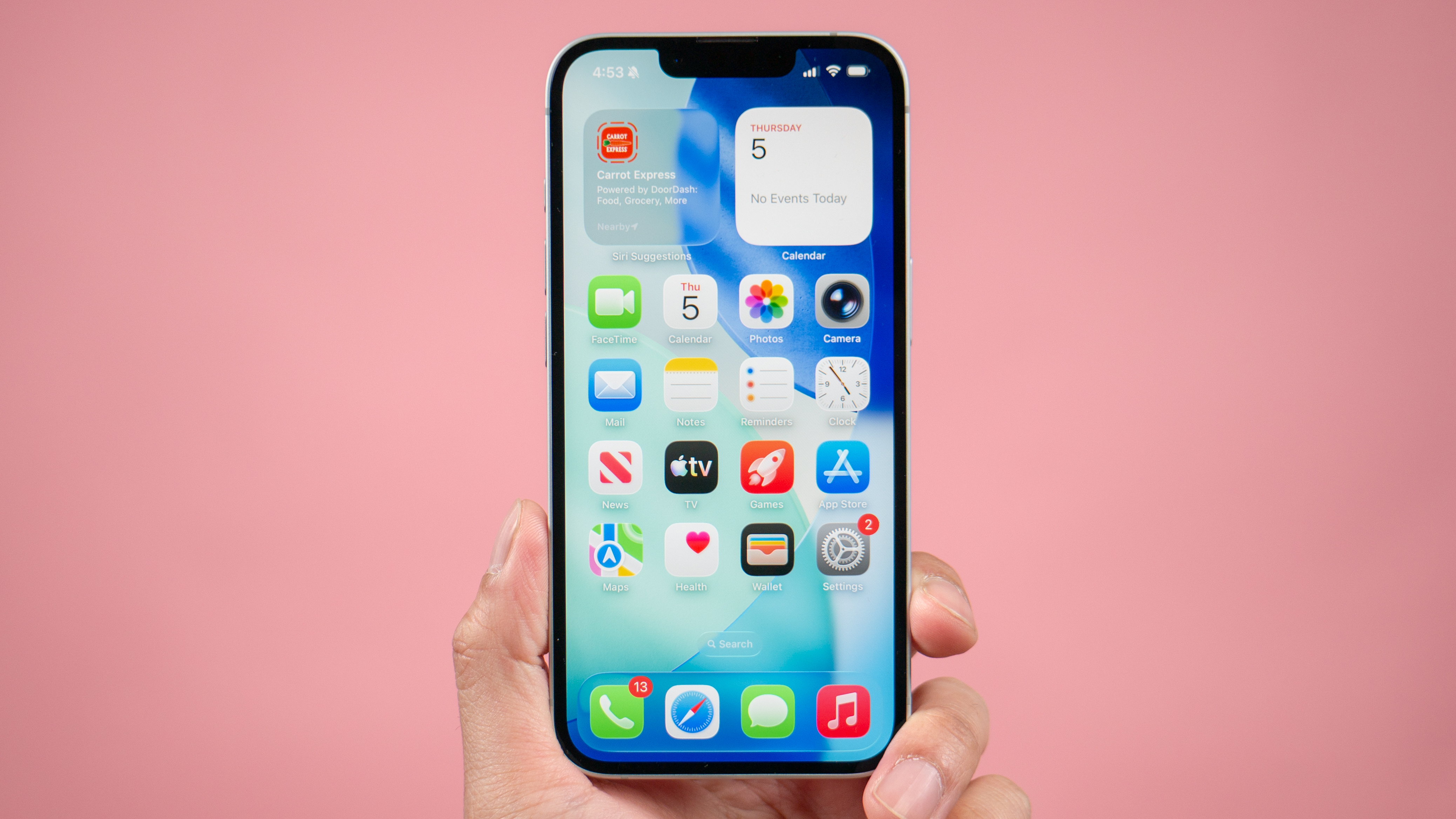 Apple iPhone 17e held in the hand showing homescreen.