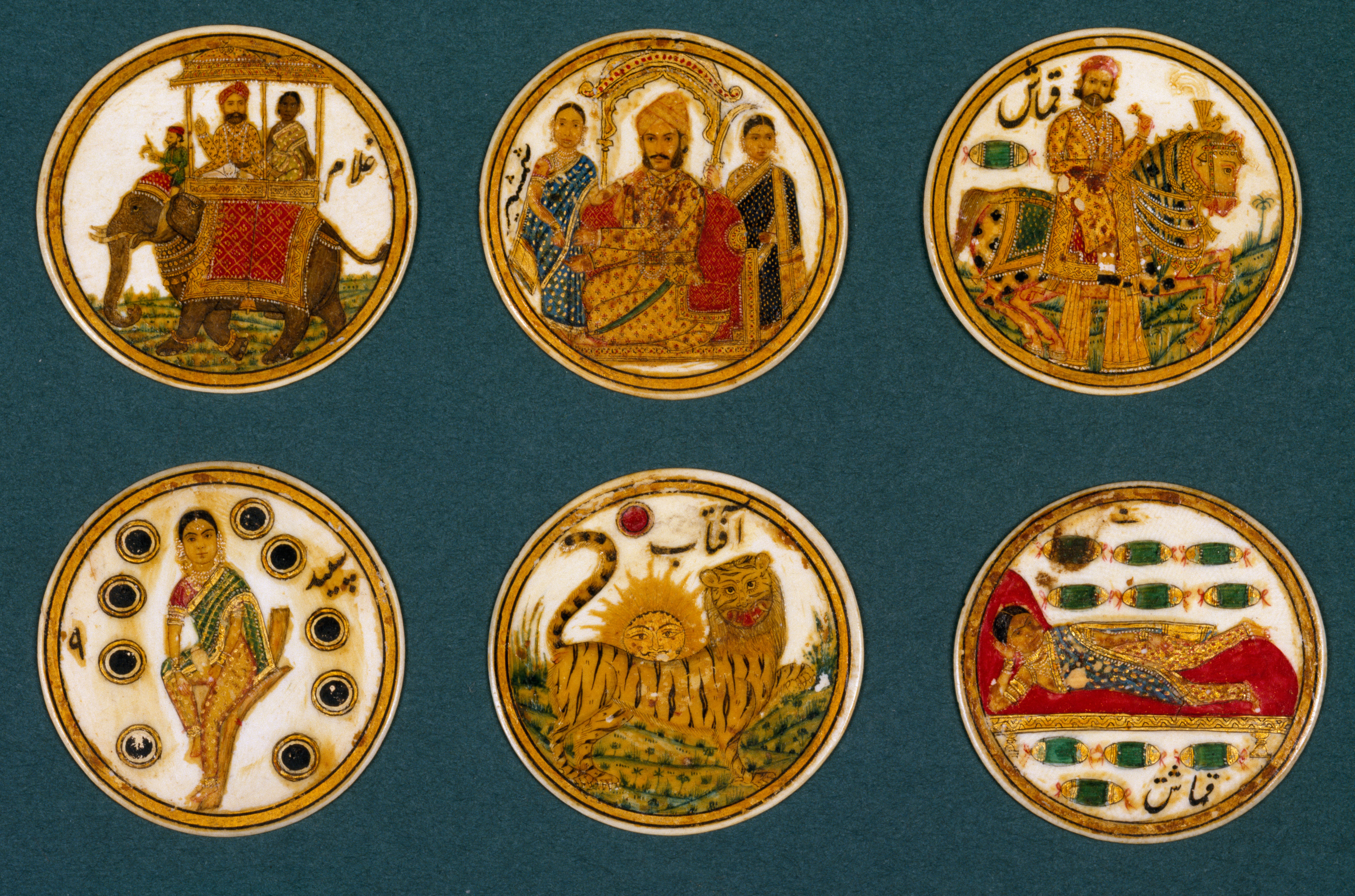Six Ganjifa cards. they are circular, with ornate images printed on each of tigers, people, horses, elephants and so on