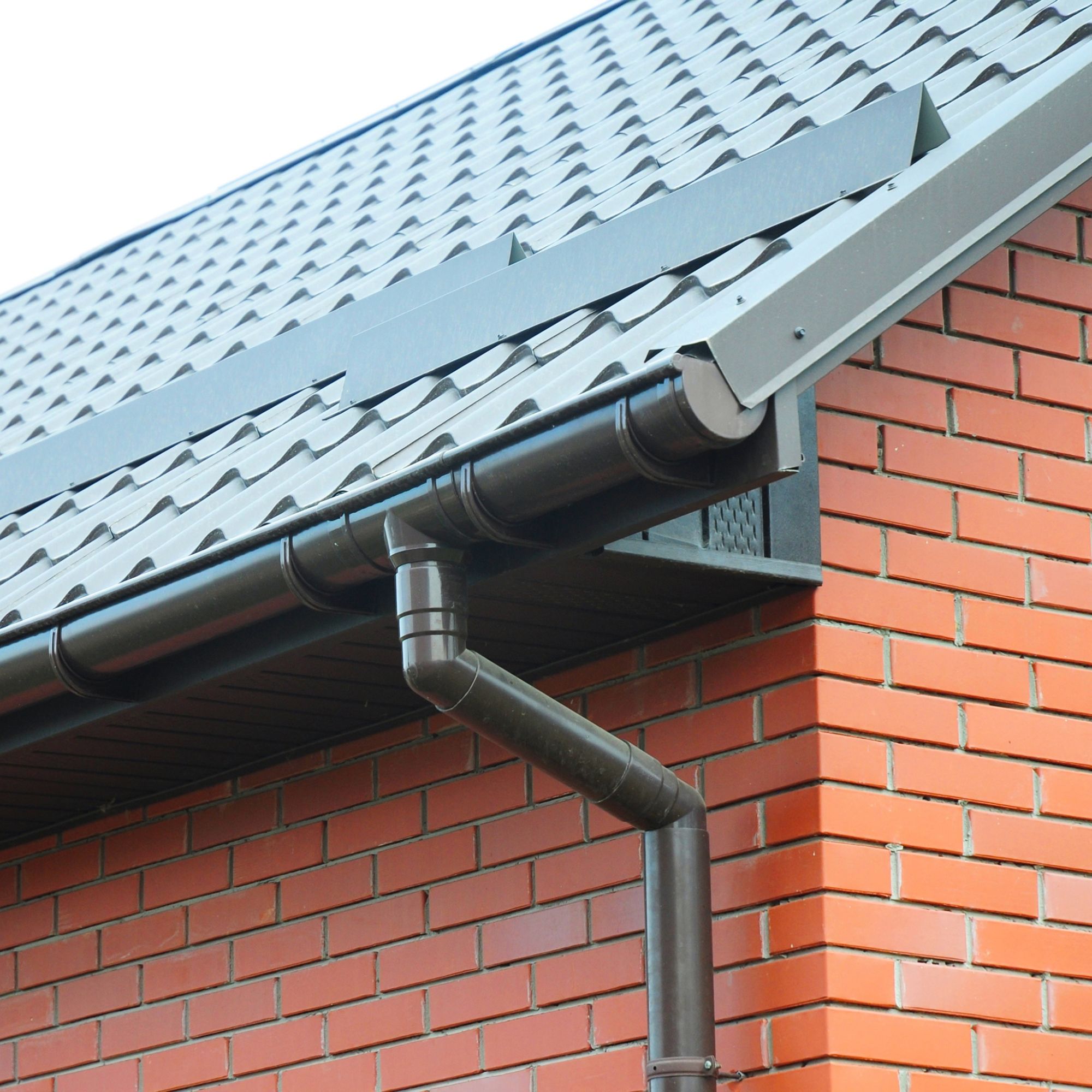 Plastic rain gutter system on eaves of house
