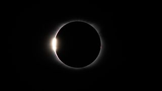 a ring of light with a bright dot along the leftmost edge, on a black background