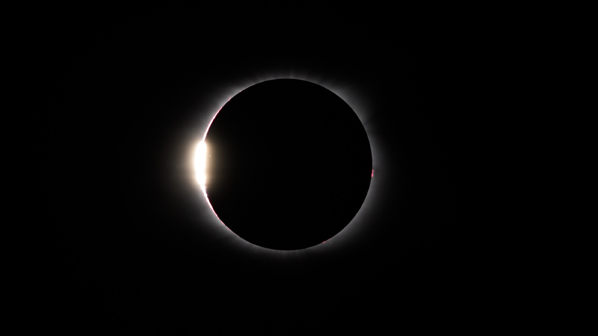 a ring of light with a bright dot along the leftmost edge, on a black background