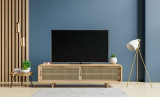 A Tv on a stand in a living room with blue walls