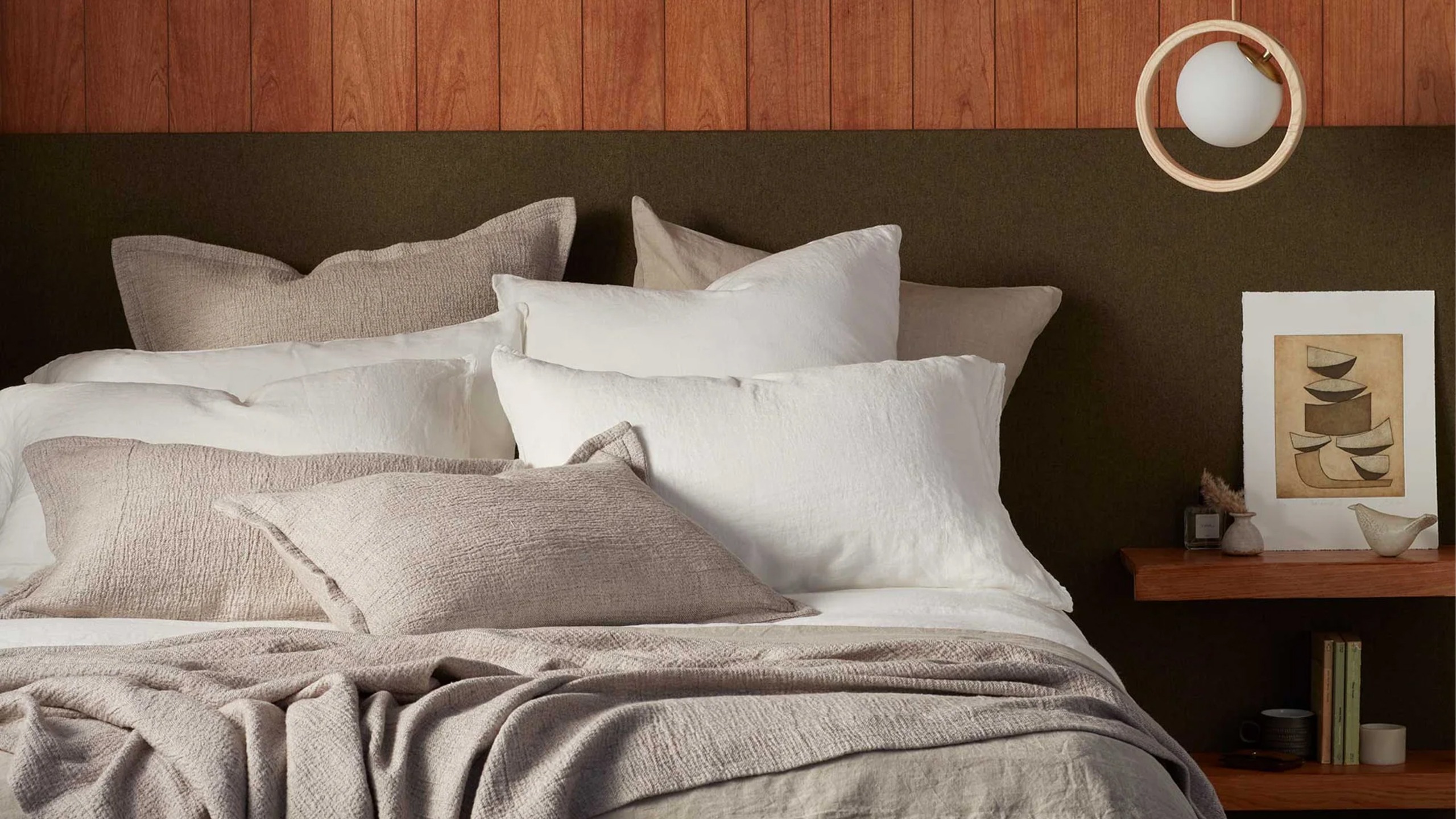 A bed with six or seven pillows on from the Secret Linen Store
