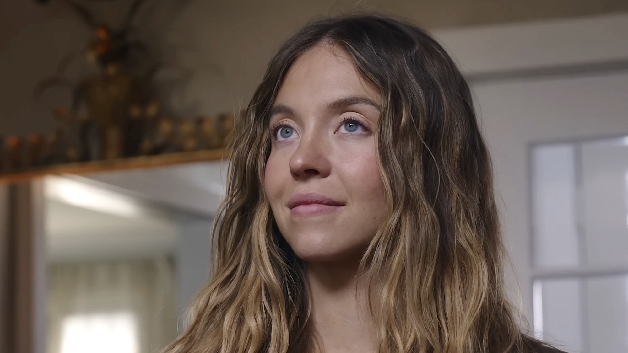 Millie smiling deviously walking through house in The Housemaid