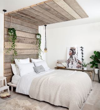 White bedroom with rustic timber plank headboard that continues onto the ceiling