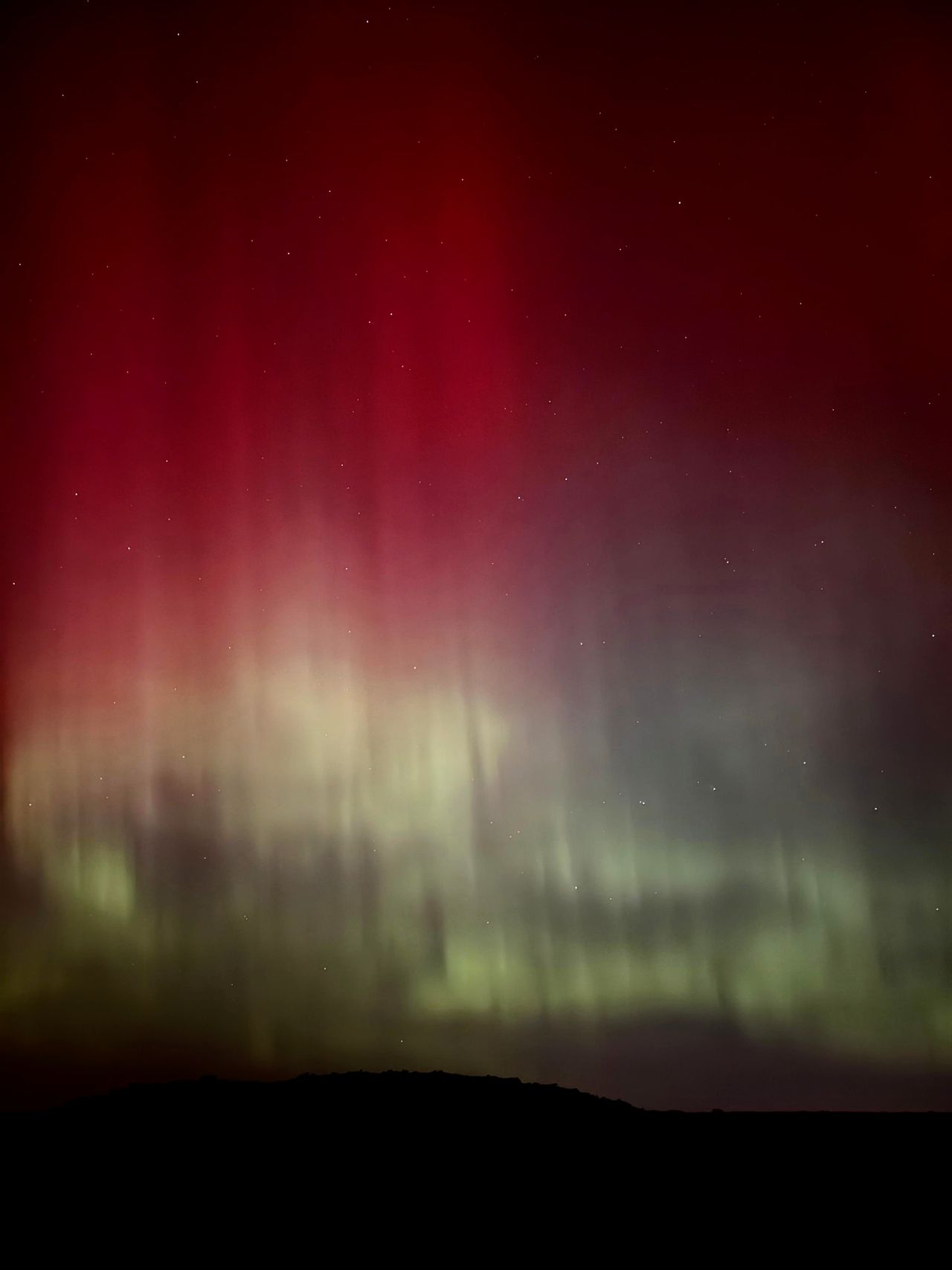 The Northern Lights' green and red pillars in the night sky