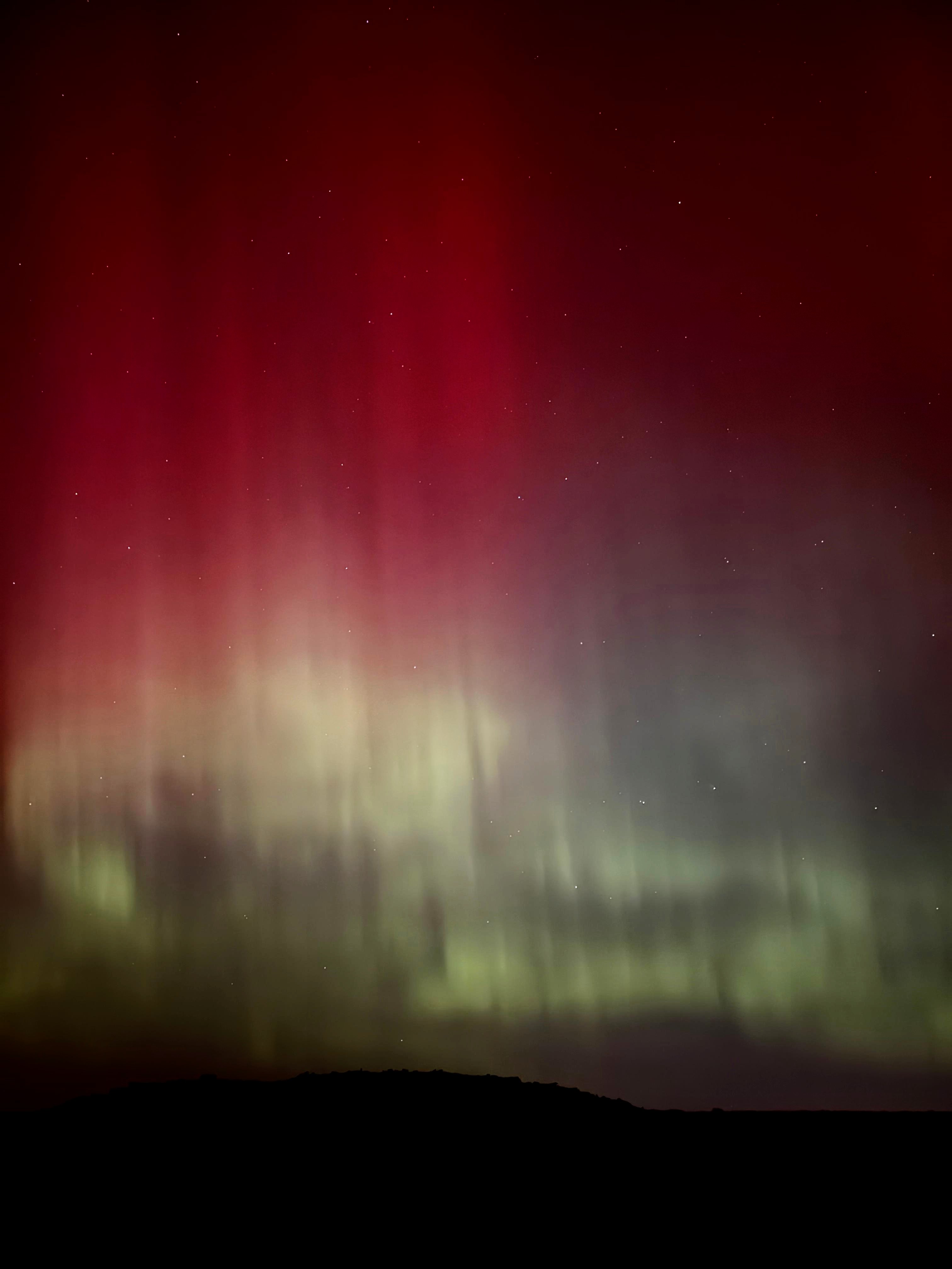 The Northern Lights' green and red pillars in the night sky