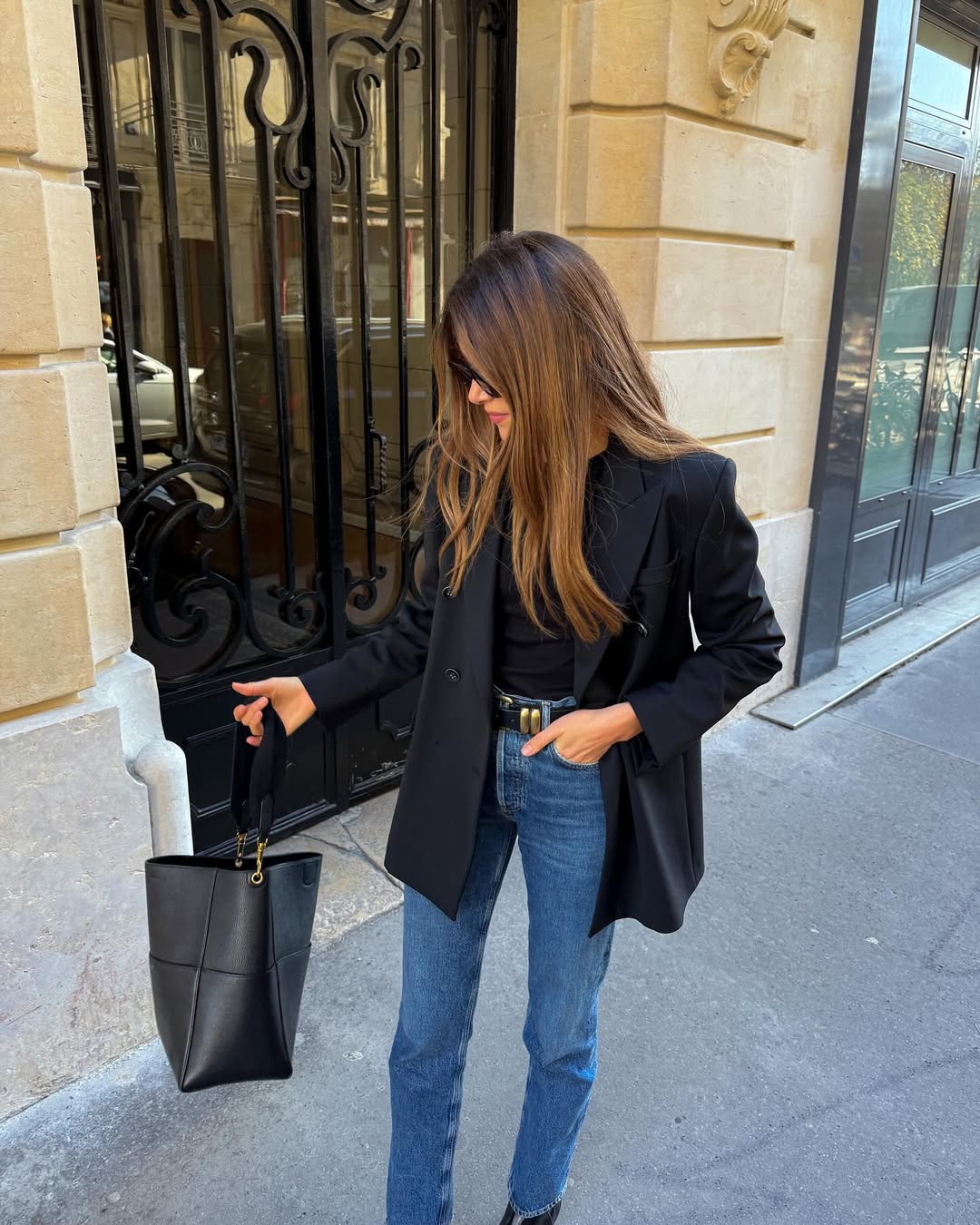 woman wearing slim jeans and black blazer