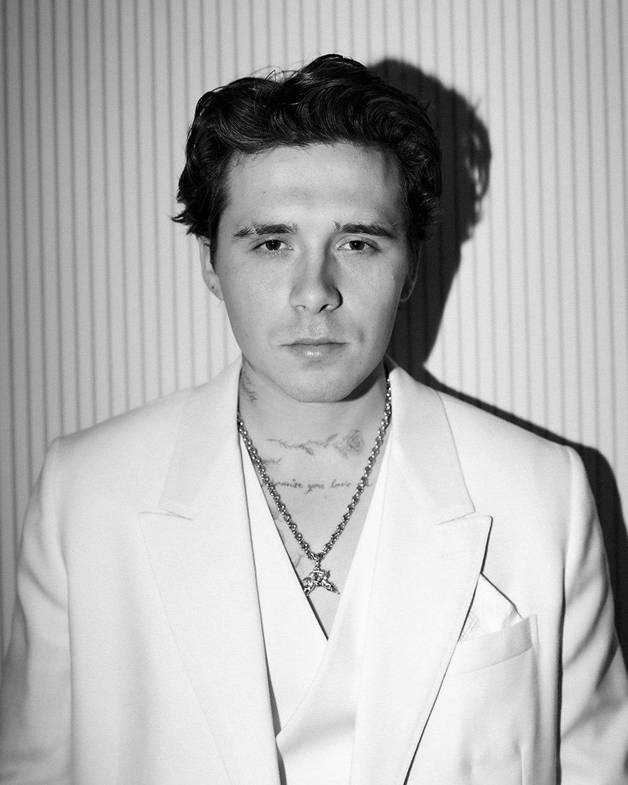 Black and white photo of Brooklyn Peltz Beckham wearing white Dior suit.