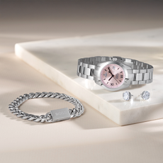 Beaverbrooks silver watch, earrings and bracelet on white table.