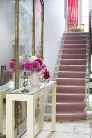 Hallway with mirror and pink stair runnner
