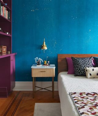 A bedroom with a blue wall in tinsel paint
