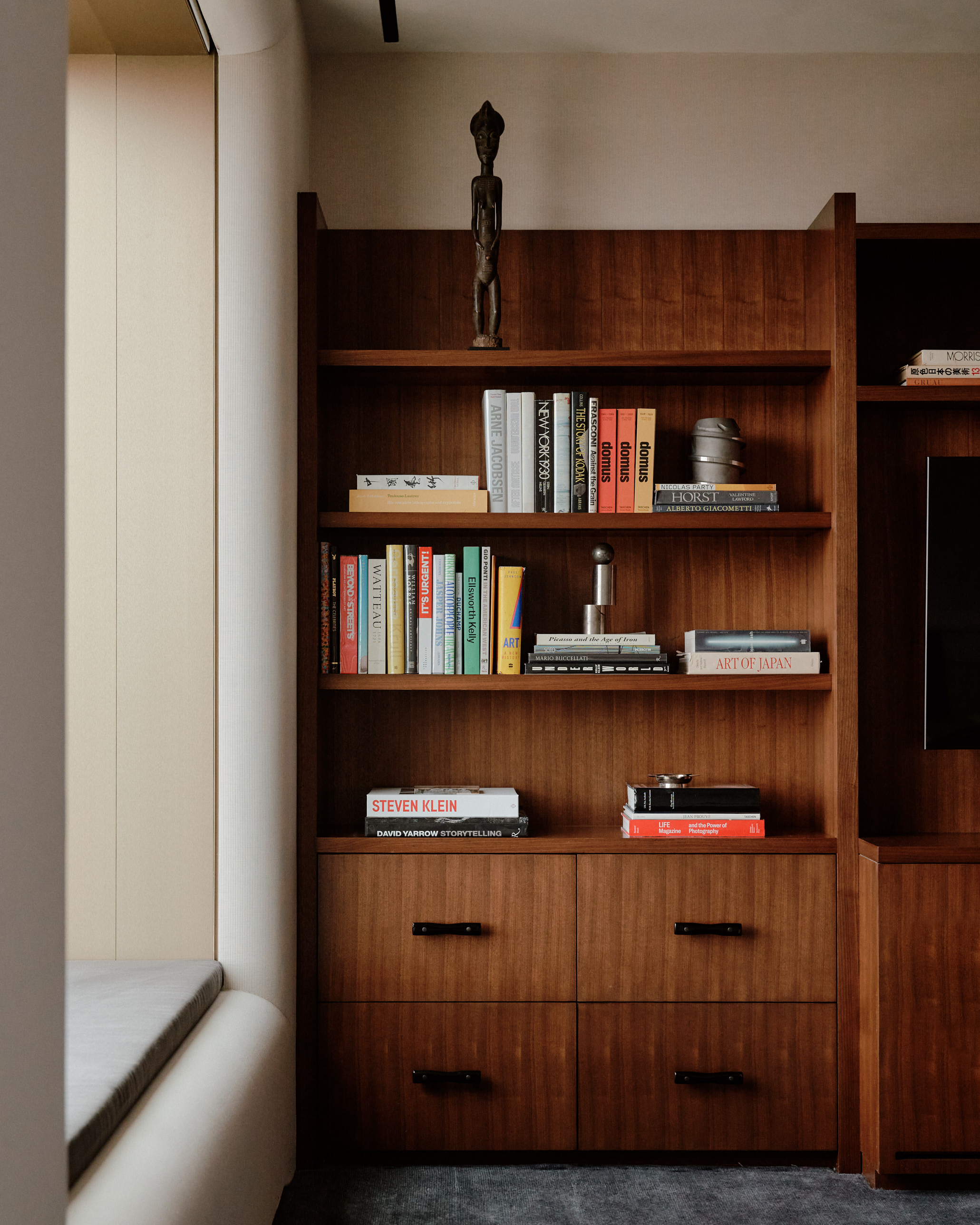 timber bookshelf in home office with books styled and a sculpture