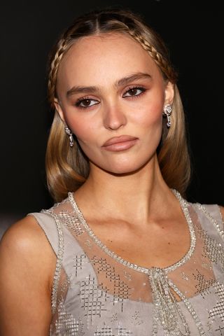 A closeup of Lily-Rose Depp wearing brown eyeshadow and lip liner on her Nosferatu press tour.