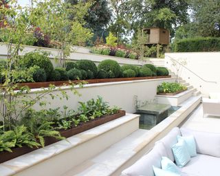 Water table garden feature in a sloping garden courtyard designed by Bowles & Wyer