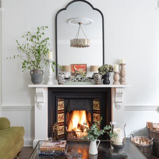 victorian fireplace wth tiled interior in living room with armchairs and alcove storage