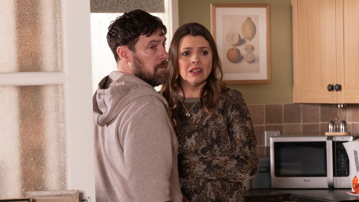 Tracy in her kitchen with Rob, looking scared 