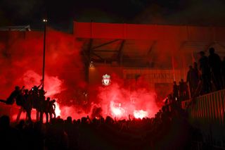 Liverpool fans celebrate outside Anfield as the team lifts the Premier League trophy inside the ground after their match against Chelsea in July 2020.