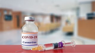 COVID-19 vaccine container and syringe