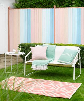 garden fence painted in pastel stripes using Sadolin