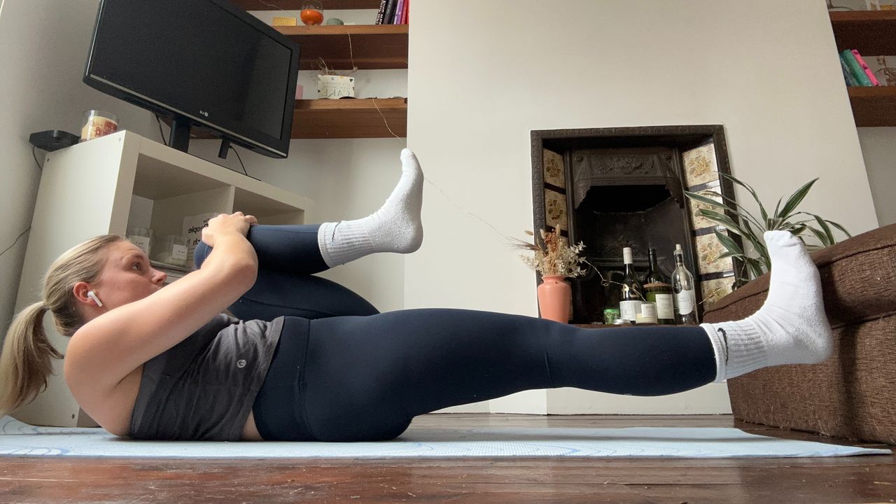 Fitness writer Alice Porter wearing workout gear performing yoga routine in her living room