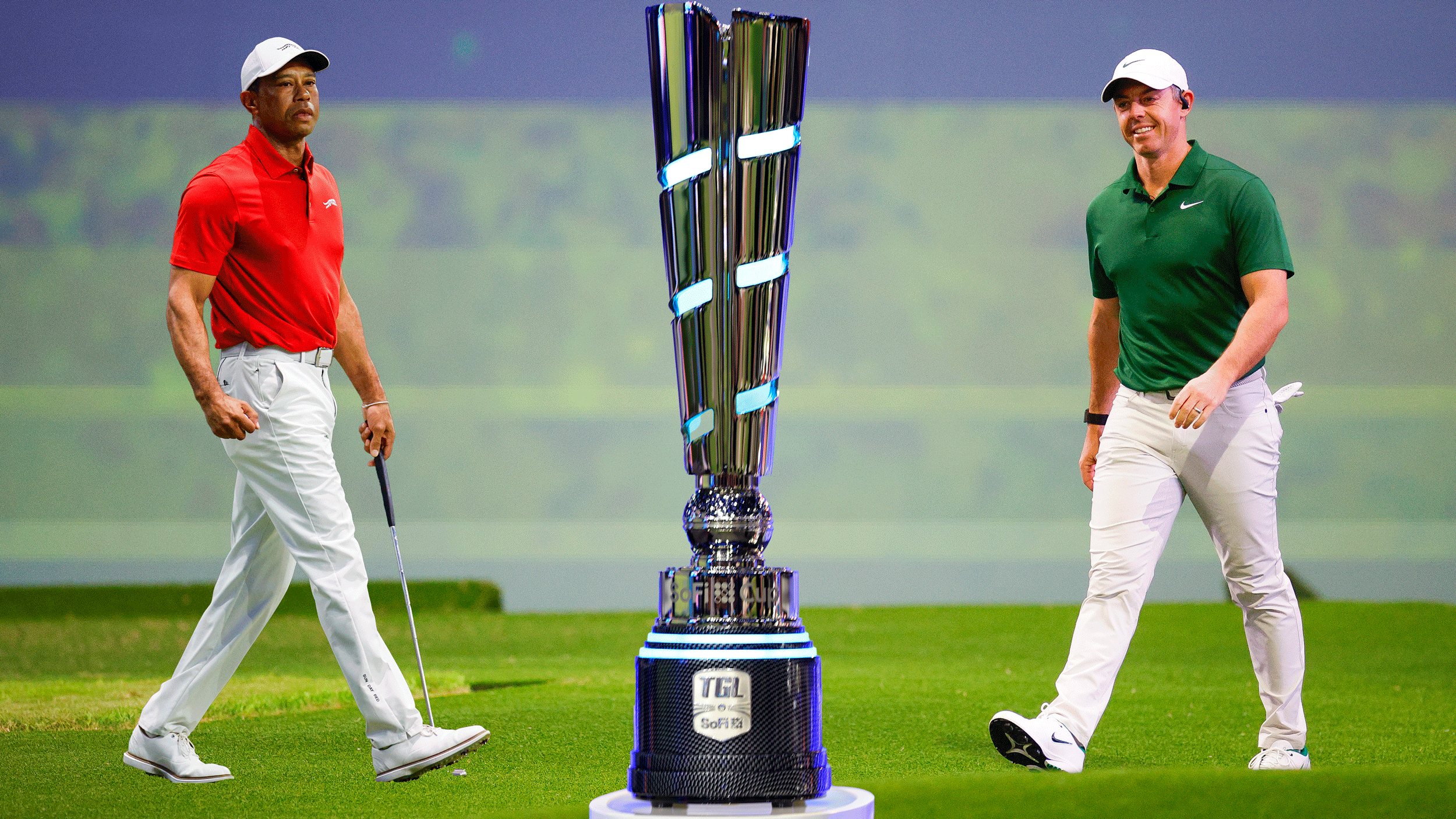 A full-length Tiger Woods (left) and a full-length Rory McIlroy (right) stand either side of the SoFi Cup