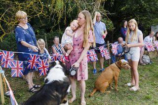 Families gathered around union jack bunting in a field