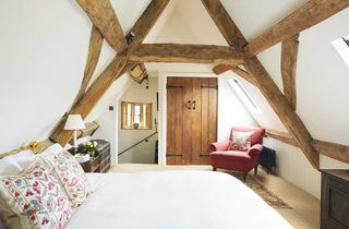 a bedroom in loft space with exposed beams